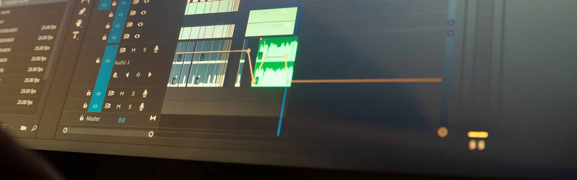Capture rapprochée d’un écran d’ordinateur affichant une timeline de montage vidéo avec des pistes audio, des effets et des transitions dans un logiciel professionnel.