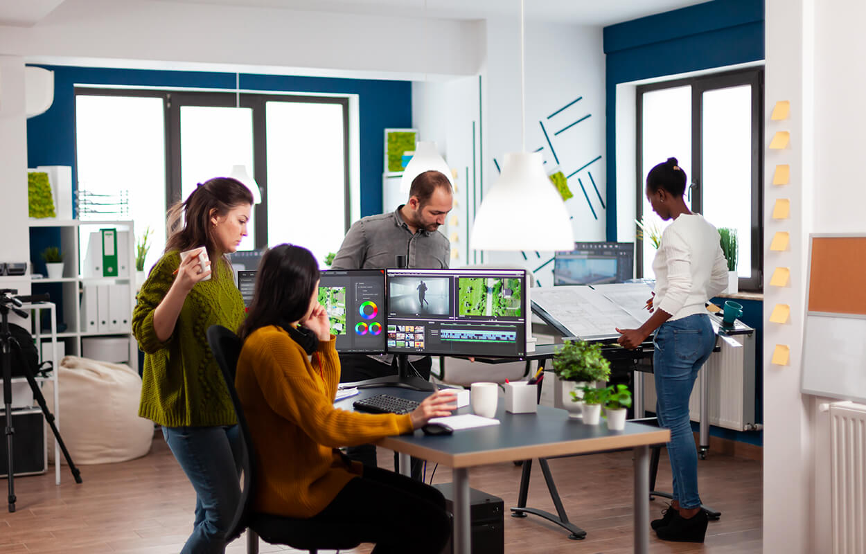 Equipe en train de travailler sur la post-production d'une réalisation vidéo dans une agence audiovisuelle