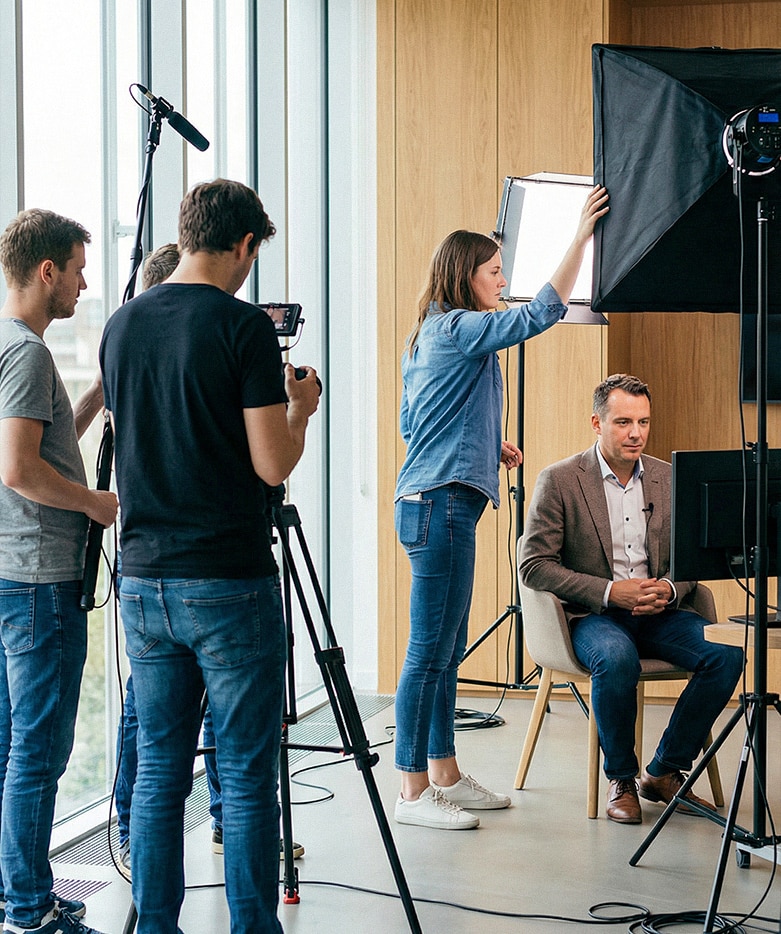 Tournage d’une interview vidéo en entreprise avec une équipe de production audiovisuelle et un dirigeant filmé dans un bureau professionnel